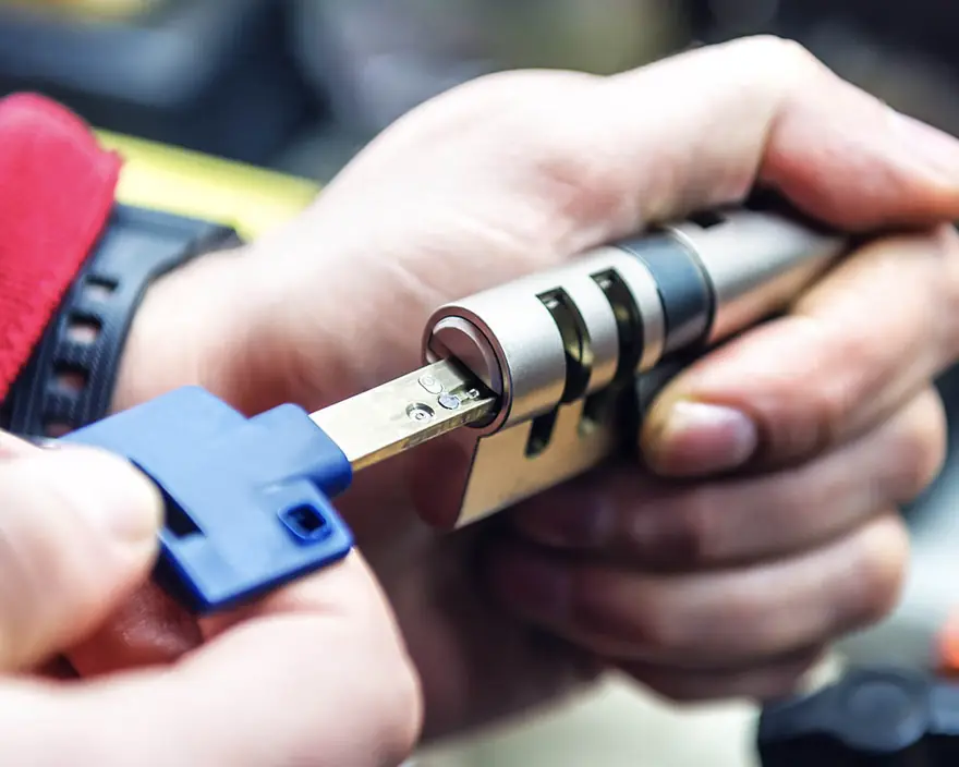 Hands fitting a key into a lock cylinder during a rekey