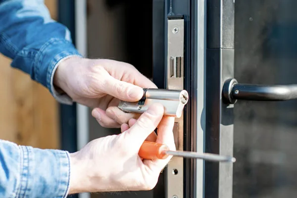 Technician installing a lock cylinder in a commercial door