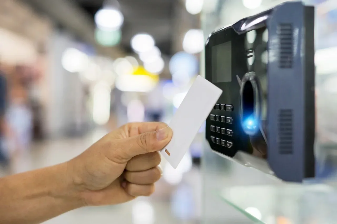 Hand presenting an access card to a commercial entry reader