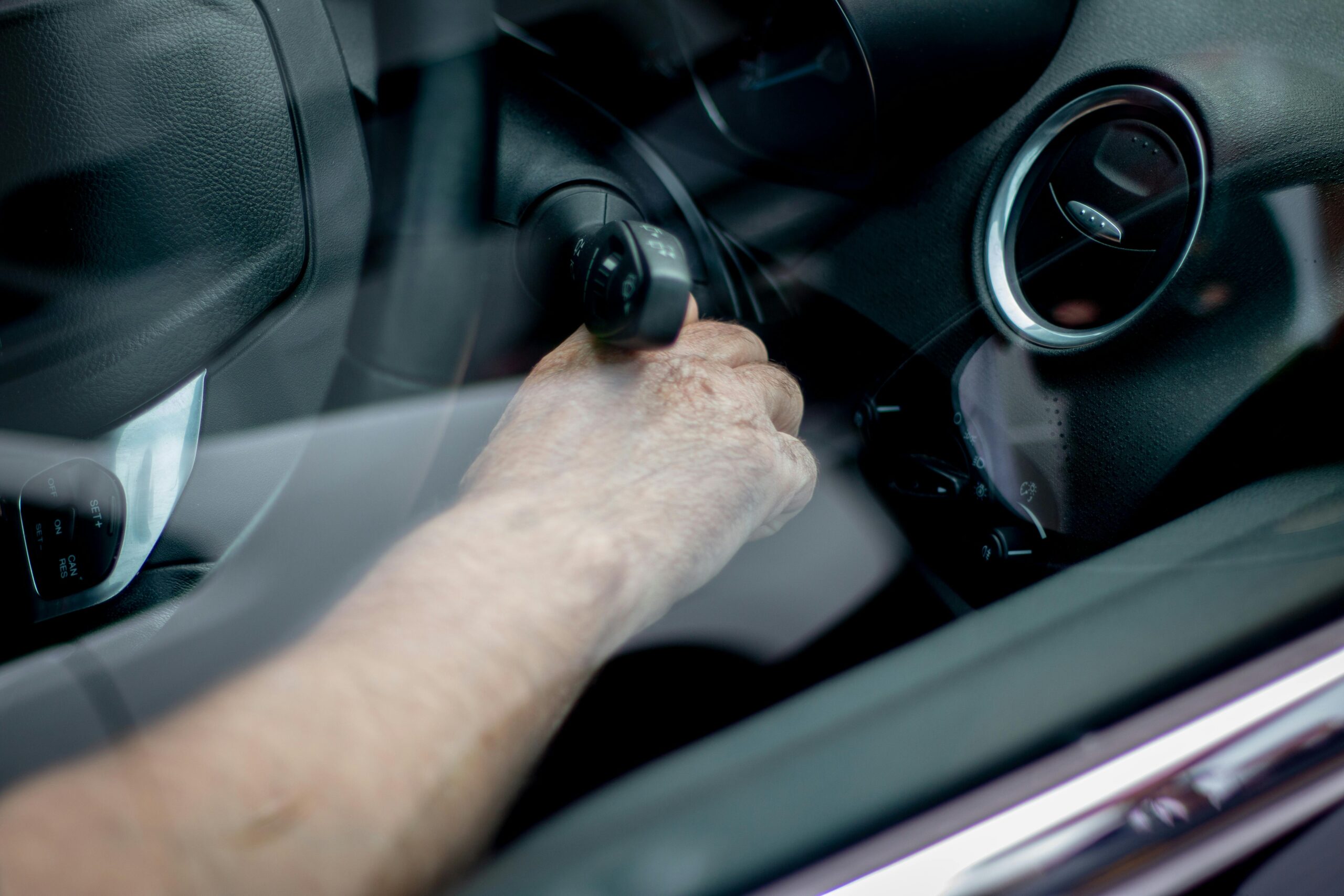 Hand turning a key in a vehicle ignition