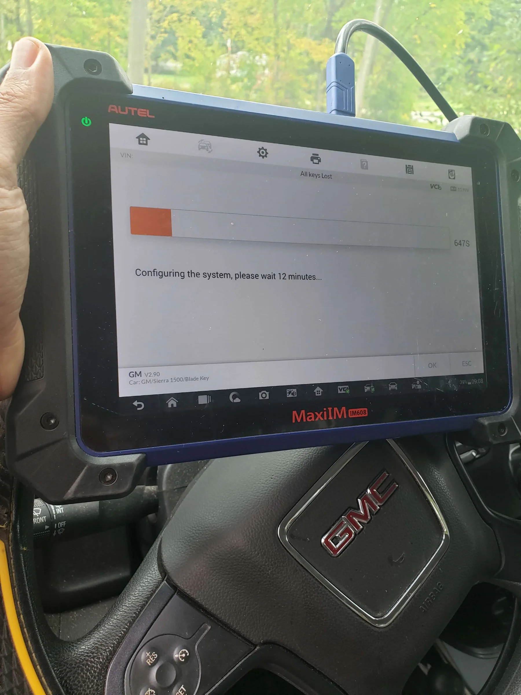 Automotive key-programming tool configuring a vehicle key system inside a GMC