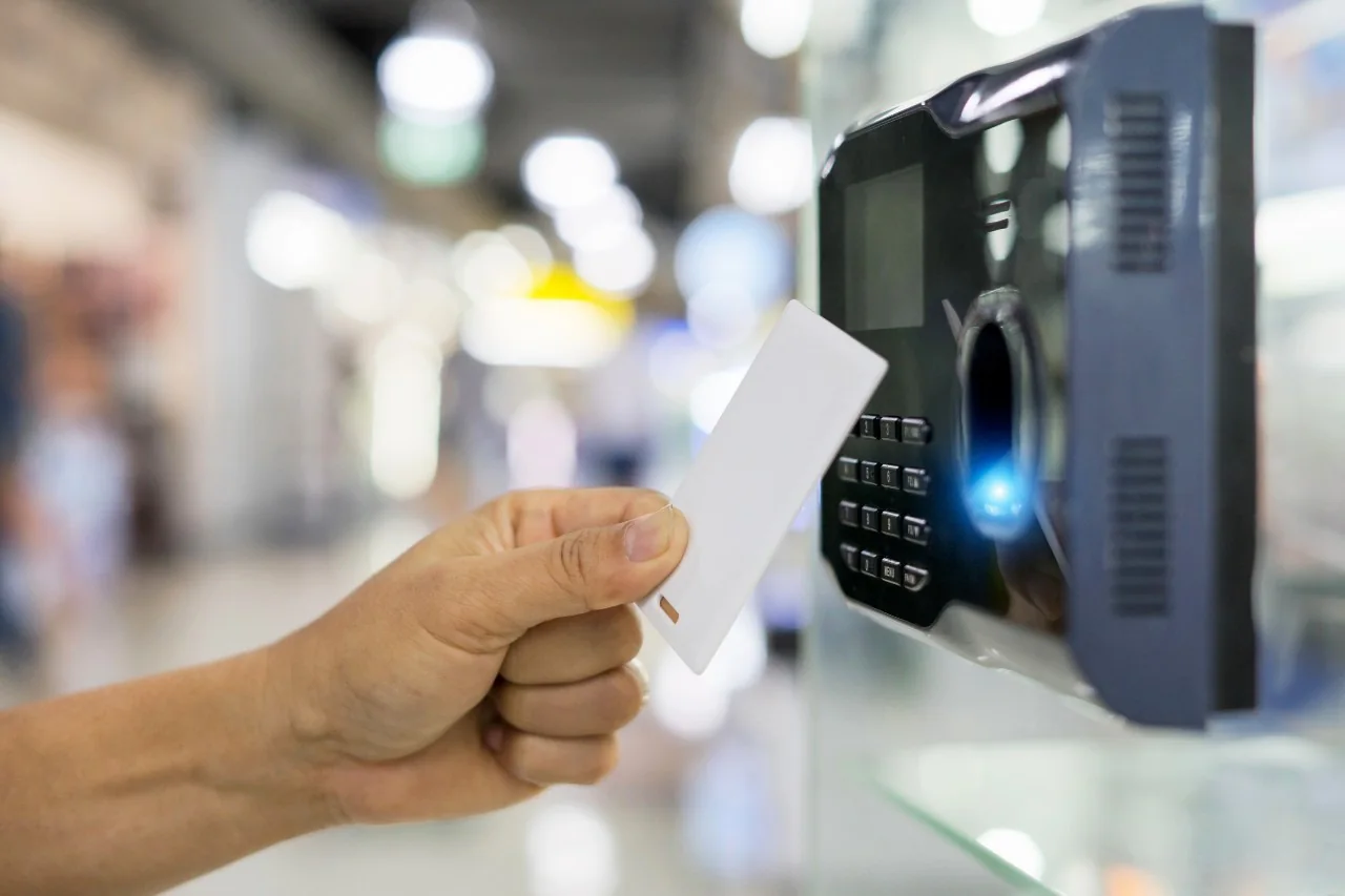 Hand presenting an access card to a commercial entry reader