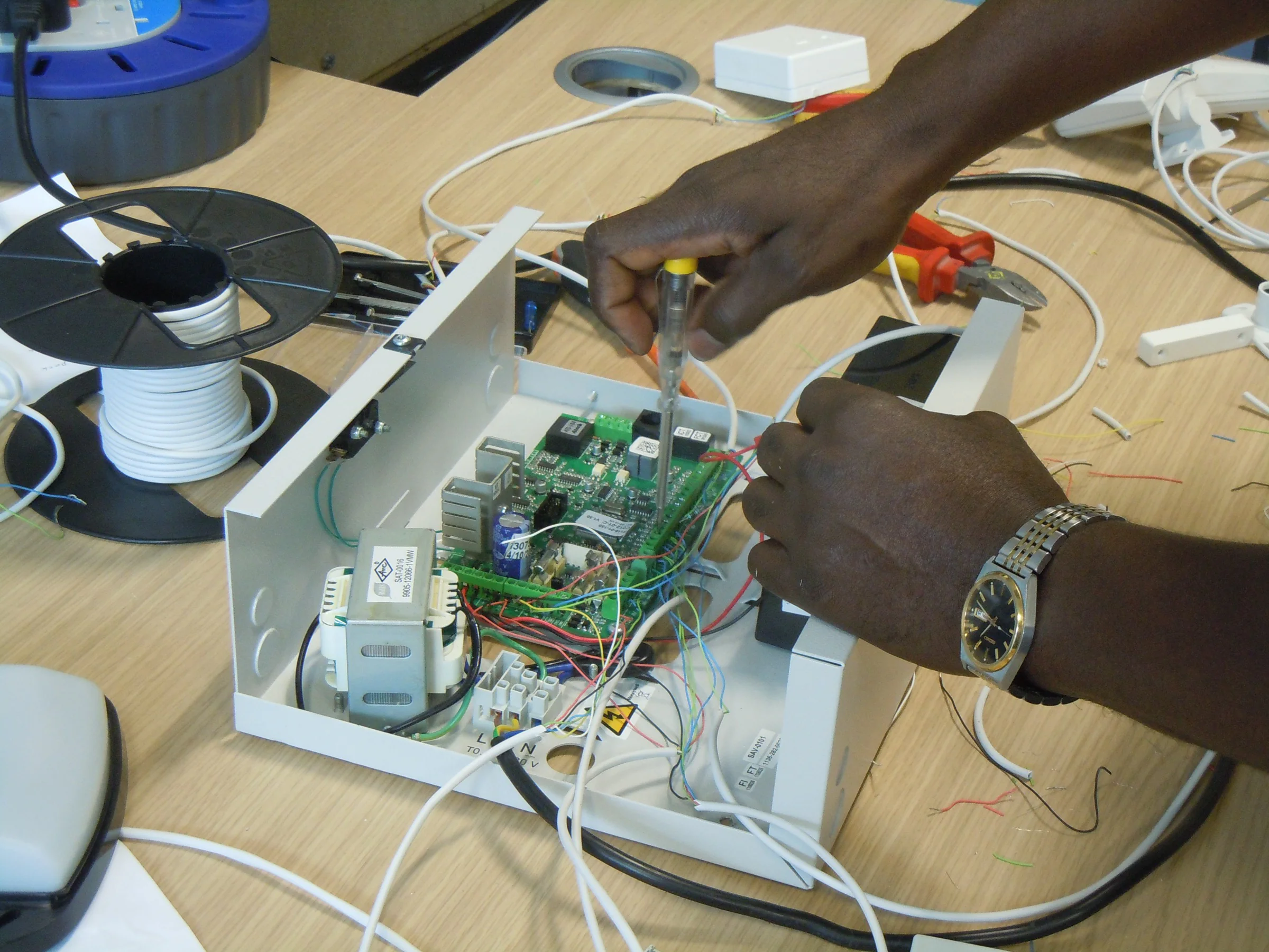 Technician wiring and testing an intrusion-alarm control panel