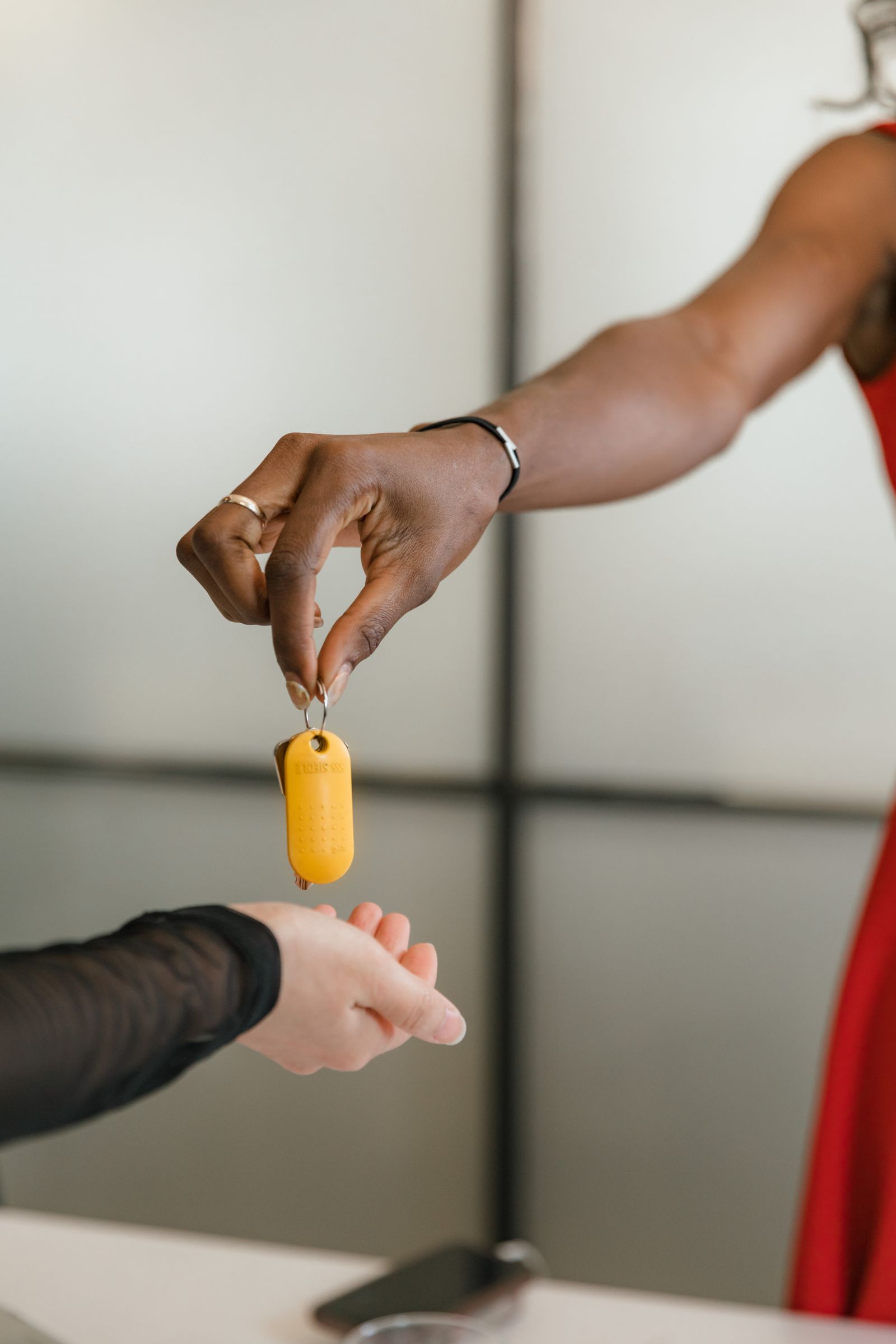 One person handing a property key or credential fob to another